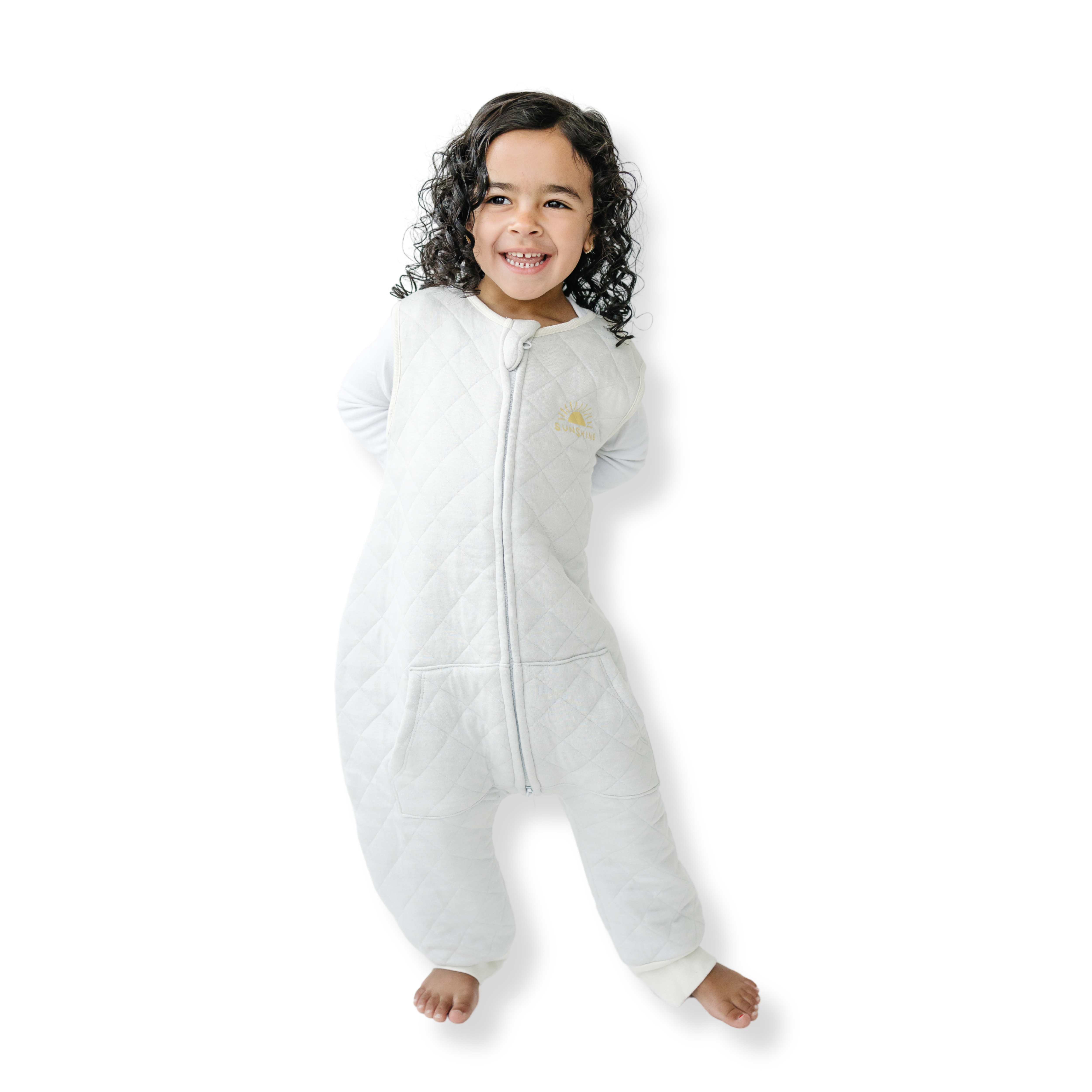 A baby standing comfortably in a Tealbee Dreamsuit, featuring buttery soft and cozy fabric made of 70% Bamboo Rayon and 30% Organic Cotton. Designed as a sleep sack with feet for walkers, ensuring both comfort and safety.
