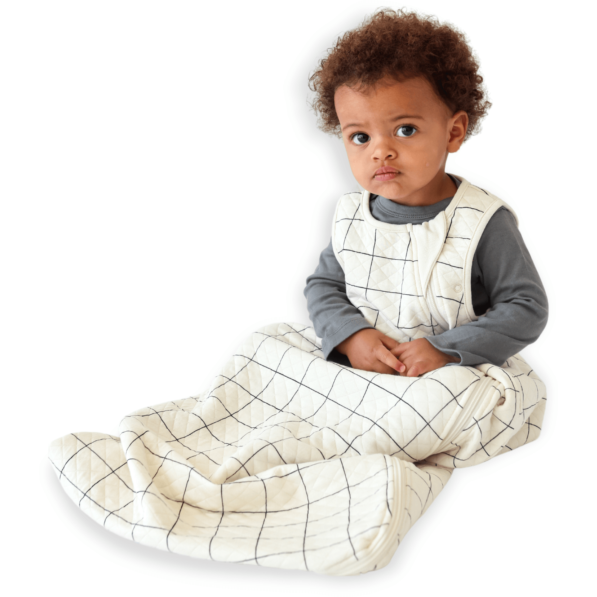 A baby sitting down comfortably in a Tealbee Dreambag 1.2 TOG, highlighting the perfect combination of warmth, coziness, and freedom of movement for a happy, restful sleep.