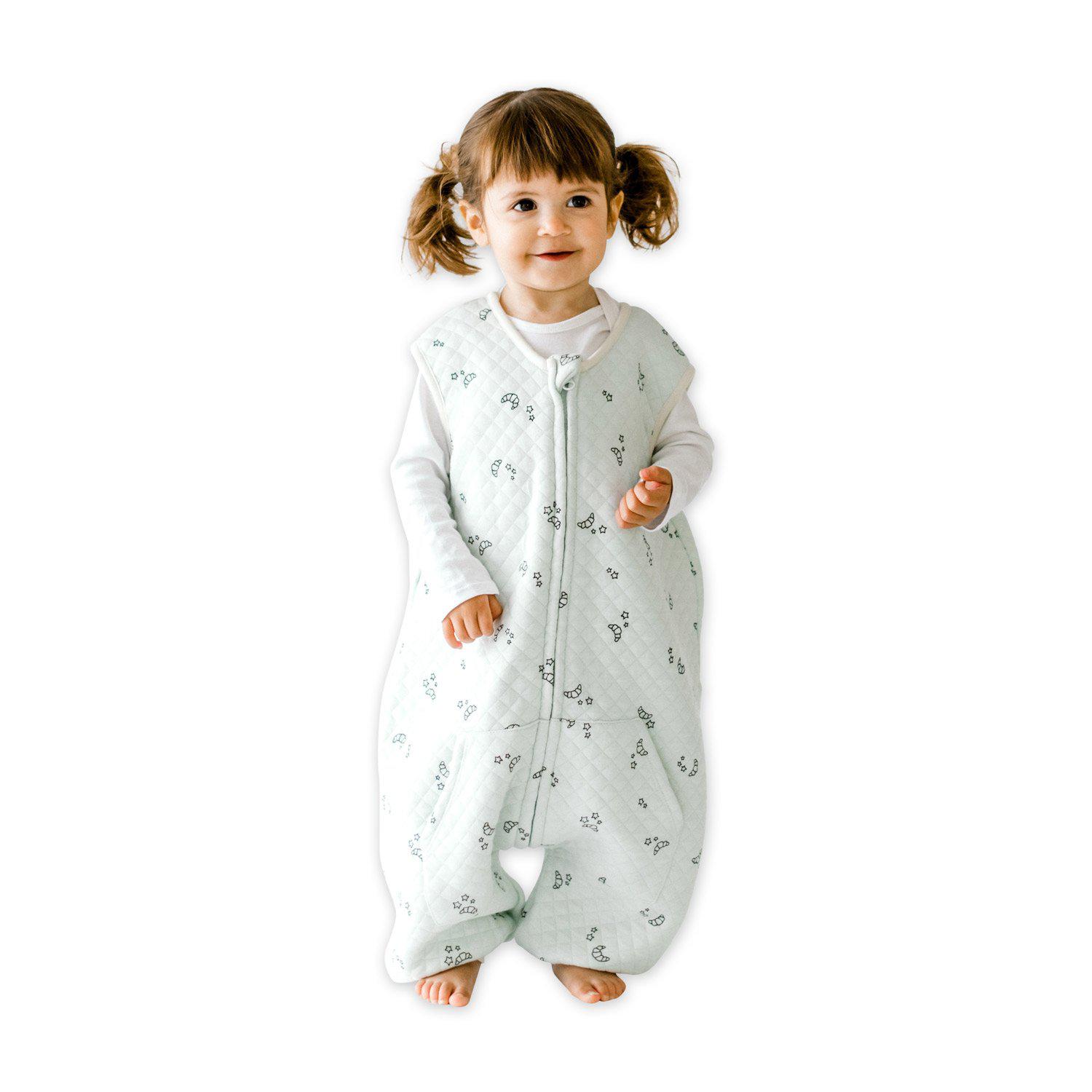 A baby standing comfortably in a Tealbee Dreamsuit, featuring buttery soft and cozy fabric made of 70% Bamboo Rayon and 30% Organic Cotton. Designed as a sleep sack with feet for walkers, ensuring both comfort and safety.