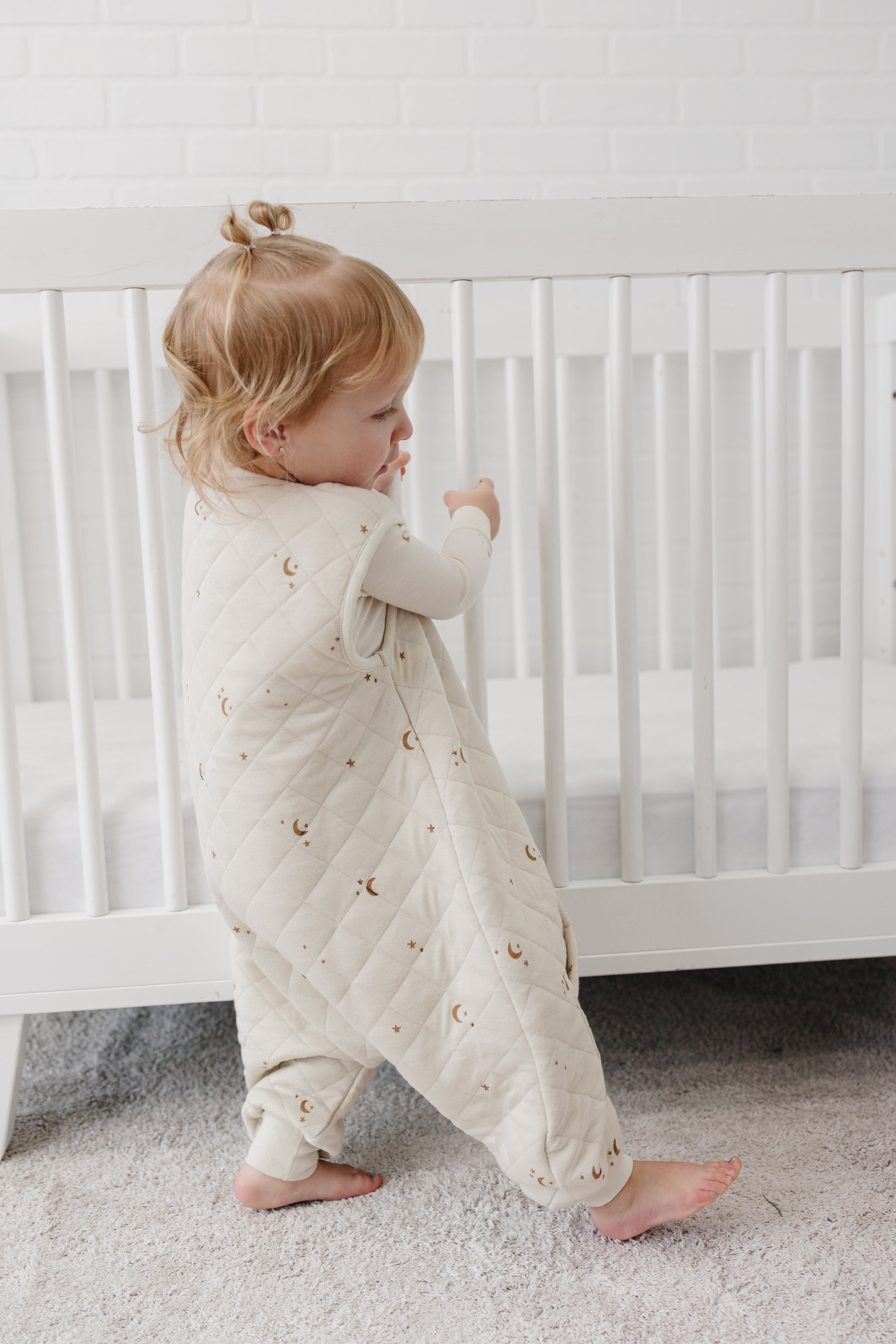 child wearing tealbee dreamsuit sleep sack with legs with matching tealbee pajamas