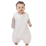 A baby standing comfortably in a Tealbee Dreamsuit, featuring buttery soft and cozy fabric made of 70% Bamboo Rayon and 30% Organic Cotton. Designed as a sleep sack with feet for walkers, ensuring both comfort and safety.