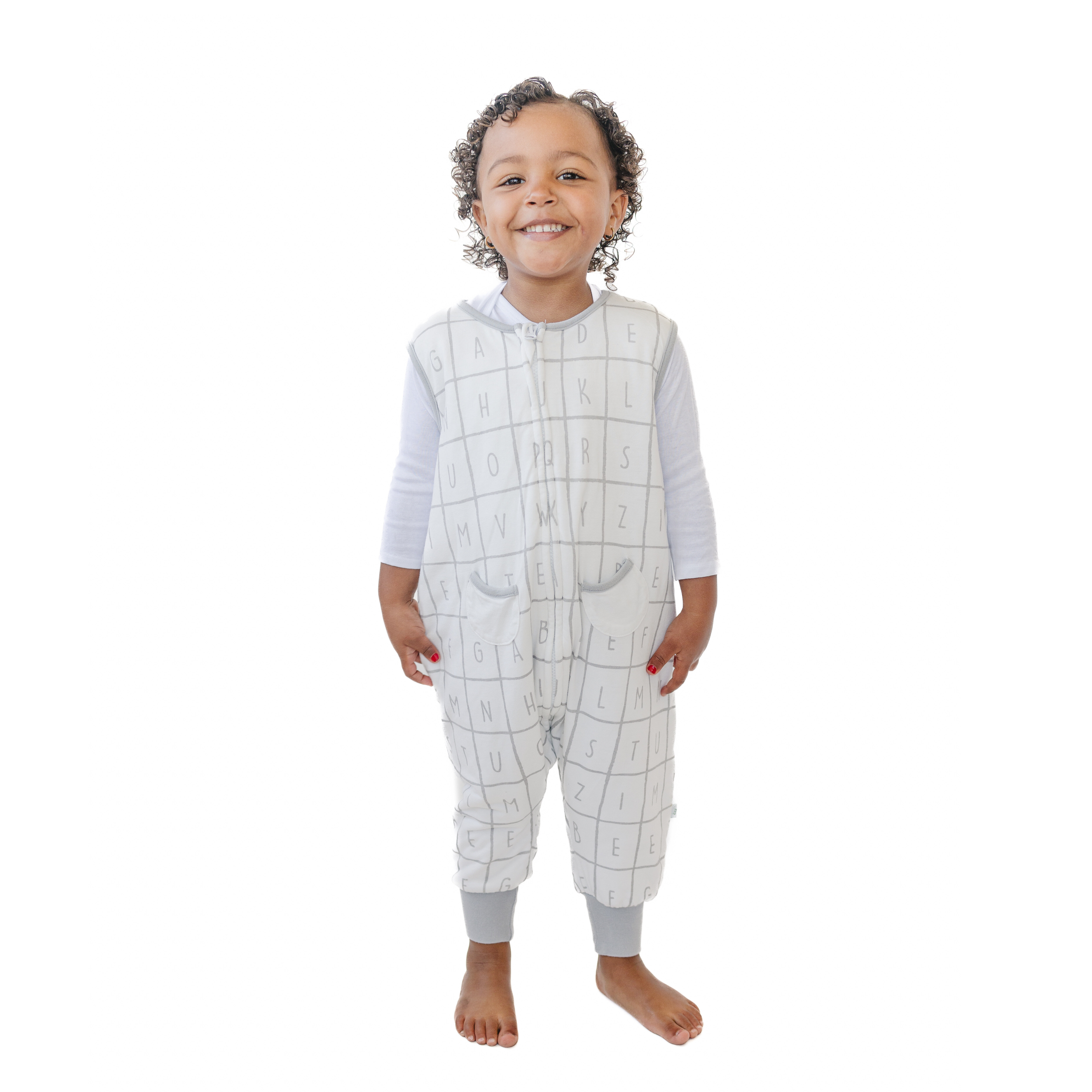 A baby standing comfortably in a Tealbee Dreamsuit, featuring buttery soft and cozy fabric made of 70% Bamboo Rayon and 30% Organic Cotton. Designed as a sleep sack with feet for walkers, ensuring both comfort and safety.