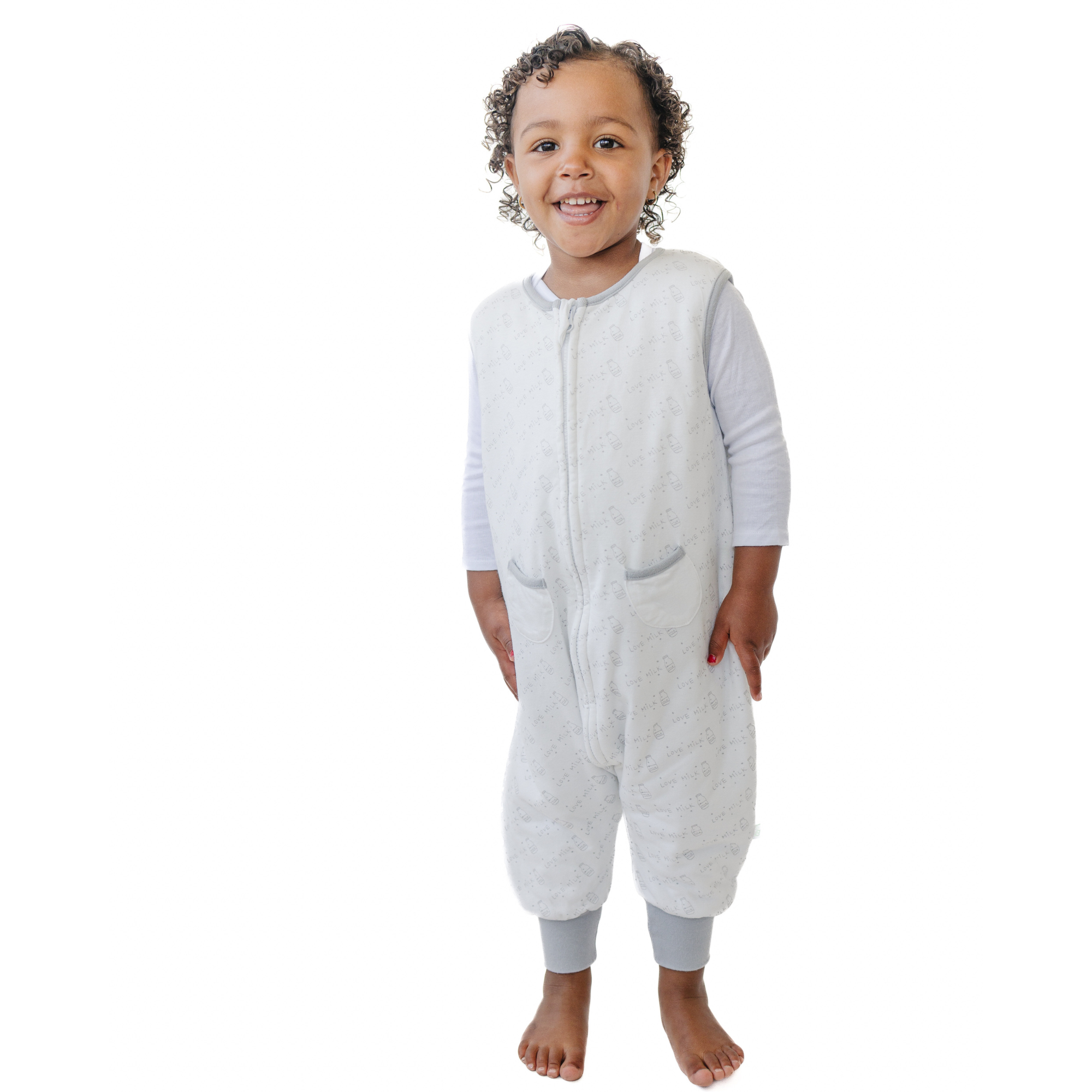 A baby standing comfortably in a Tealbee Dreamsuit, featuring buttery soft and cozy fabric made of 70% Bamboo Rayon and 30% Organic Cotton. Designed as a sleep sack with feet for walkers, ensuring both comfort and safety.