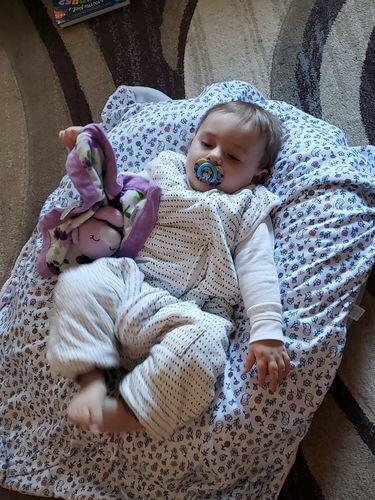 Baby in tealbee dreamsuit in brushed dots with a pacifier
